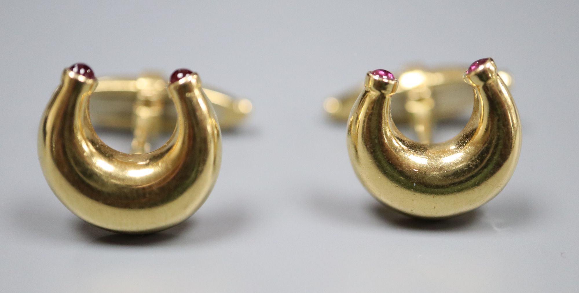 A pair of modern 18ct gold and ruby set horseshoe shaped cufflinks by Mappin & Webb